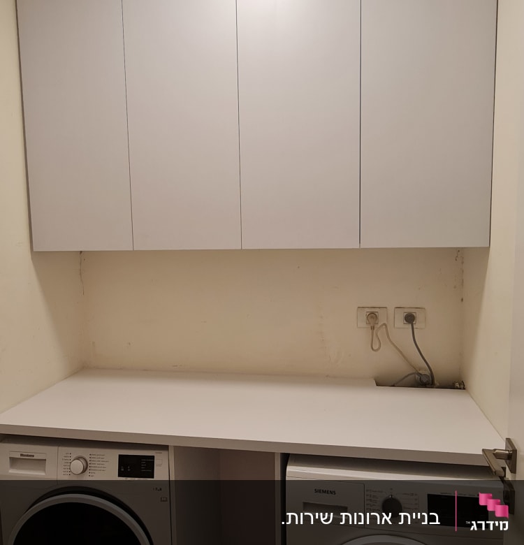 ארונות לבנים מעל מכונת כביסה ומייבש